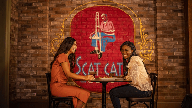 A mom and daughter laughing while sitting at a table at Port Orleans French Quarter